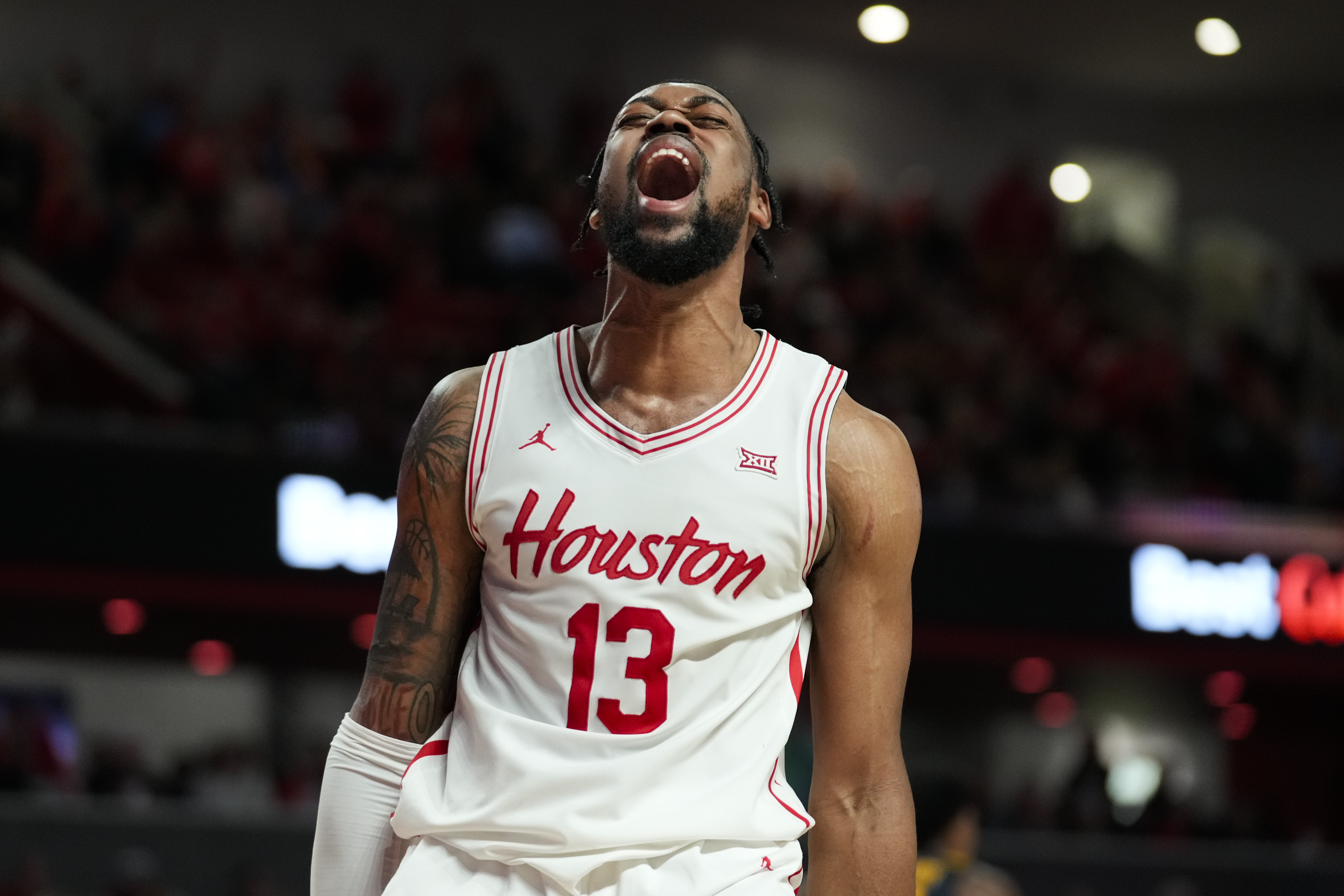 Houston forward J'Wan Roberts reacts after dunking during the second half of an NCAA college basketball game against West Virginia in Houston, Wednesday, Jan. 15, 2025.