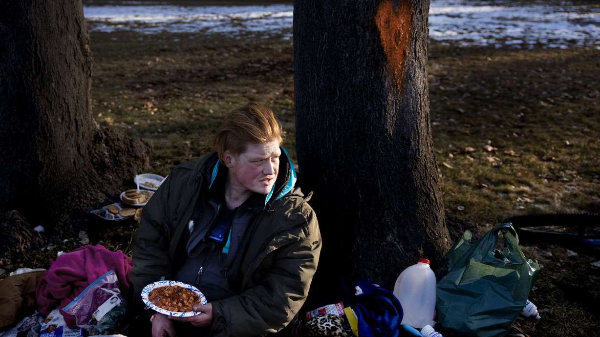 Devon Reynolds sits with his belongings at Liberty Park in Salt Lake City on Wednesday. Salt Lake City Mayor Erin Mendenhall says major gaps in homeless services and criminal justice systems must be repaired to address challenges.