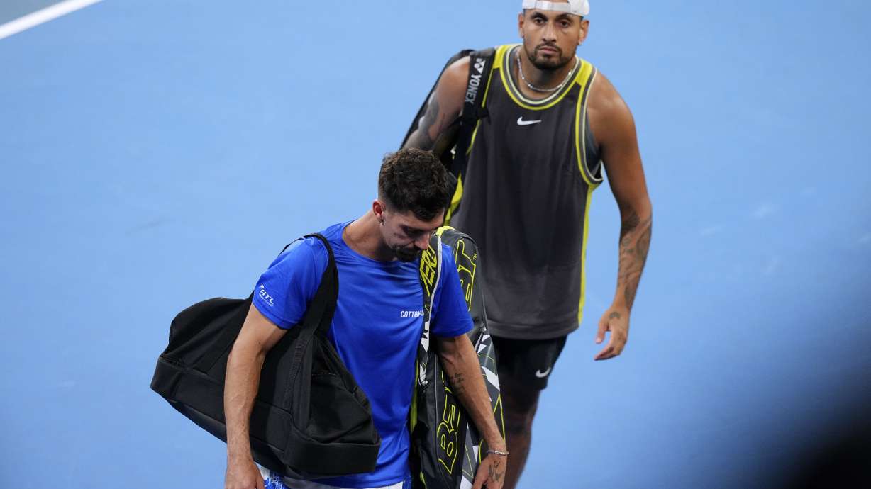 Australia's Nick Kyrgios, right, and Thanasi Kokkinakis leave the court after retiring from their first round doubles match against compatriots James Duckworth and Aleksandar Vukic at the Australian Open tennis championship in Melbourne, Australia, Thursday, Jan. 16, 2025.