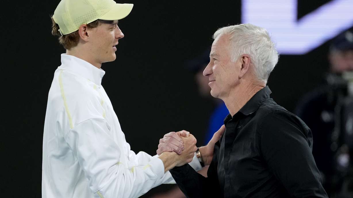 Jannik Sinner, left, of Italy shakes hands with John McEnroe after defeating Tristan Schoolkate of Australia in their second round match at the Australian Open tennis championship in Melbourne, Australia, Thursday, Jan. 16, 2025.