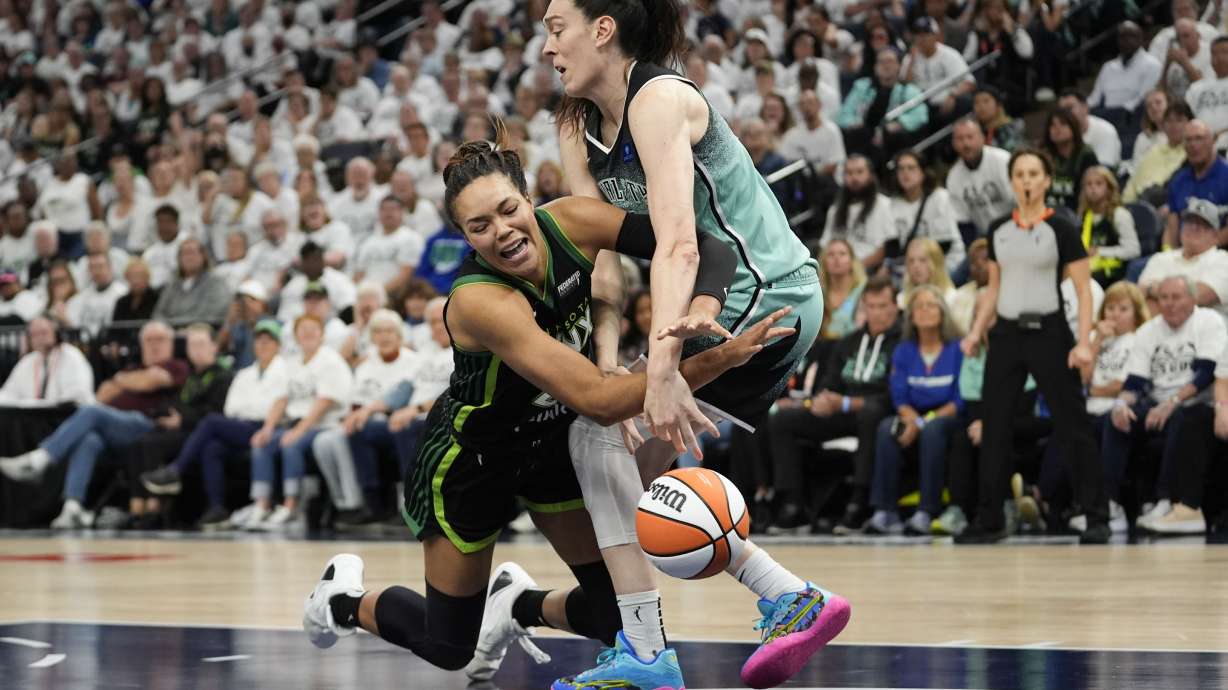 FILE -Minnesota Lynx forward Napheesa Collier and New York Liberty forward Breanna Stewart, right, battle for a loose ball during the second half of Game 4 of a WNBA basketball final playoff series, Oct. 18, 2024, in Minneapolis.