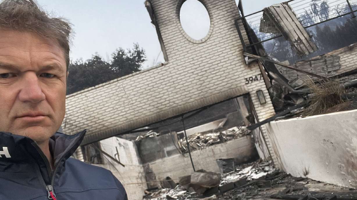 This photo provided by Townsend Bell shows Bell in front of one of his Malibu homes that was burned in the California fires on Jan. 8, 2025 in Malibu, Calif.