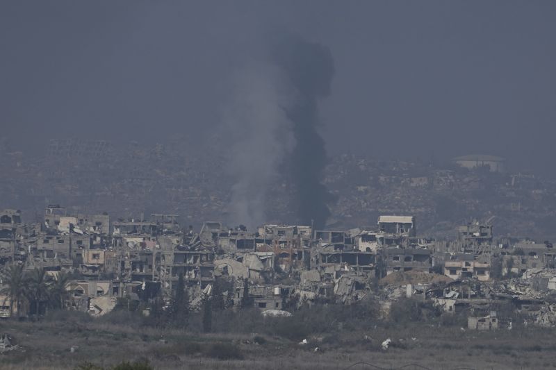 Smoke rises behind destroyed buildings by Israeli bombardments as seen inside the Gaza Strip from southern Israel, Thursday.