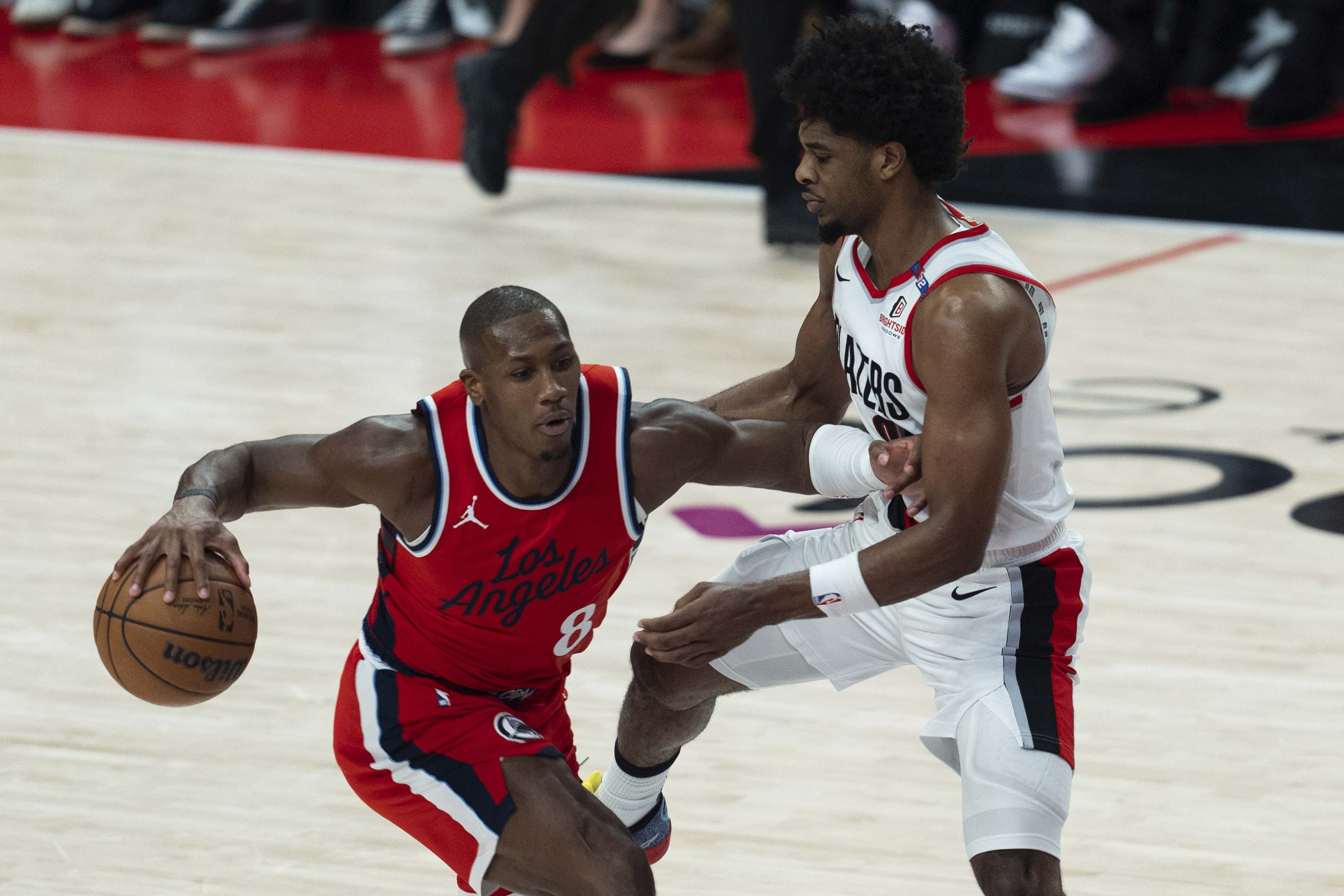 Los Angeles Clippers guard Kris Dunn (8) drives to the basket against Portland Trail Blazers guard Scoot Henderson, right, during the first half of an NBA basketball game, Thursday, Jan. 16, 2025, in Portland, Ore.