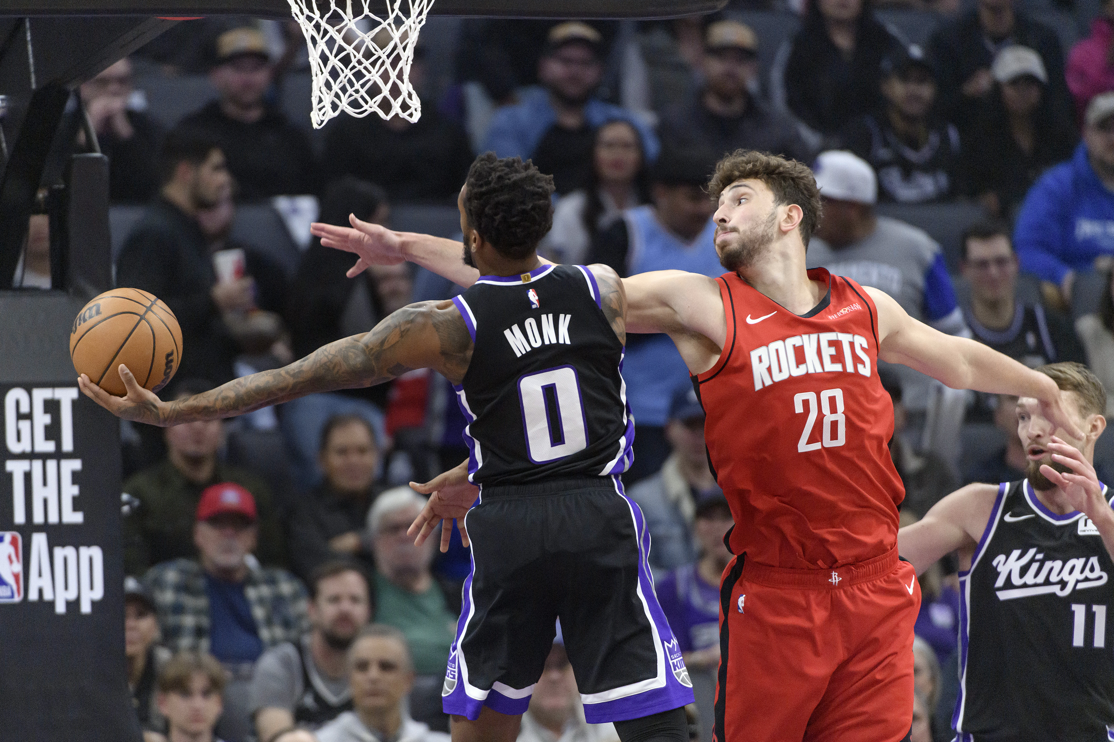 Sacramento Kings guard Malik Monk (0) is guarded by Houston Rockets center Alperen Sengun (28) during the first half of an NBA basketball game in Sacramento, Calif., Thursday, Jan. 16, 2025.
