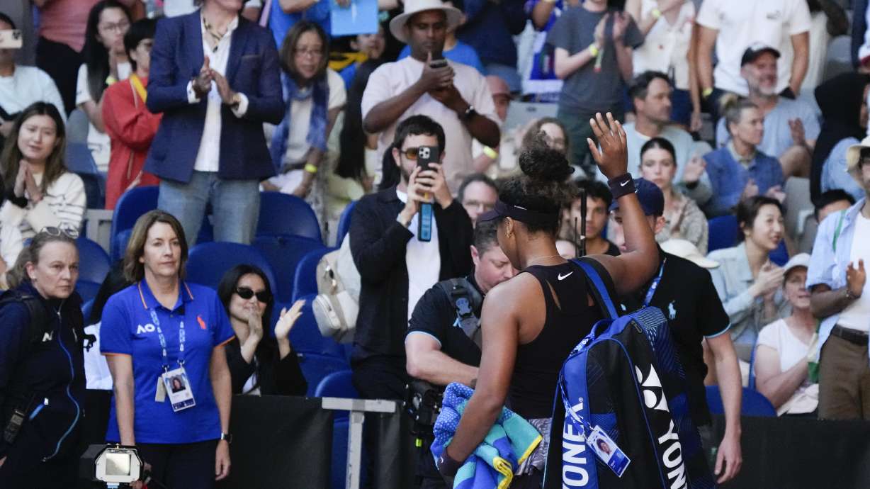 Naomi Osaka of Japan waves as she leaves the court after retiring from her third round match against Belinda Bencic of Switzerland at the Australian Open tennis championship in Melbourne, Australia, Friday, Jan. 17, 2025.