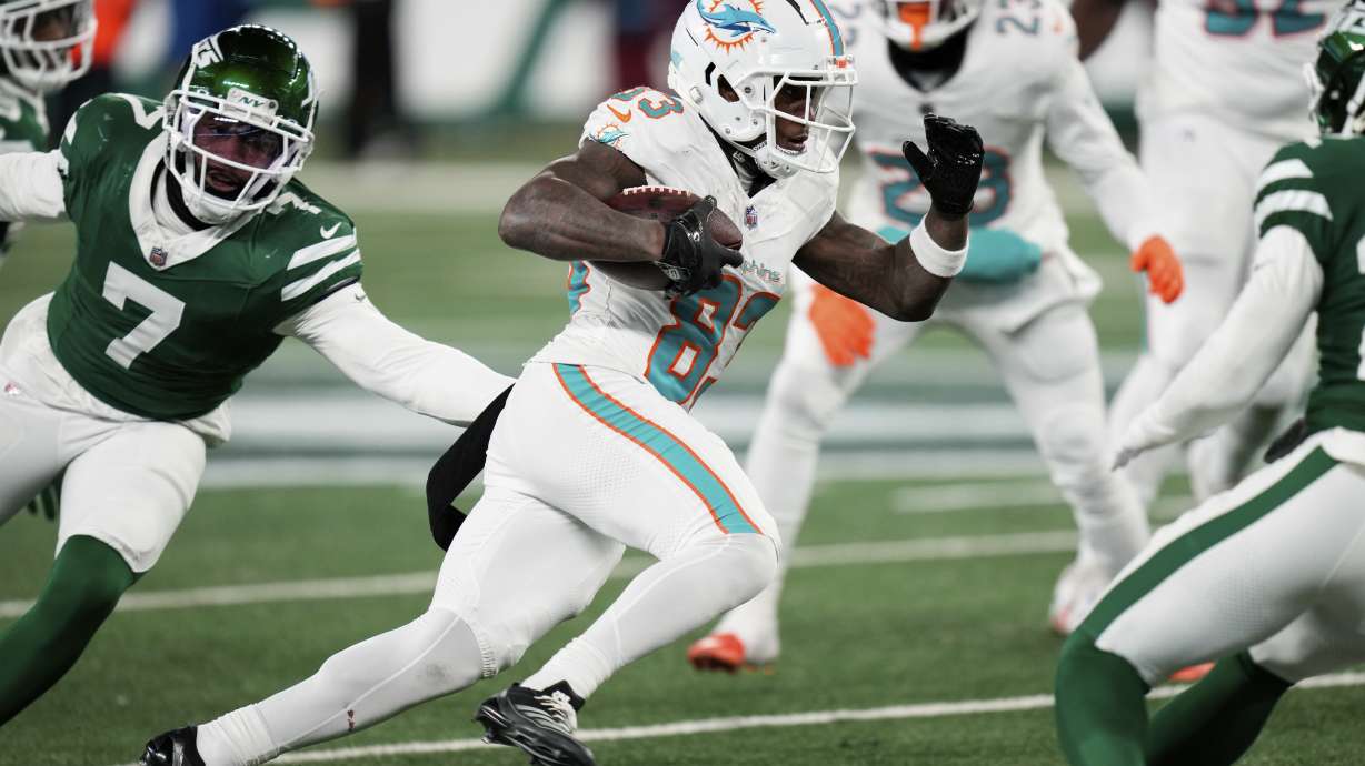 Miami Dolphins wide receiver Malik Washington, center, runs the ball during the second half of an NFL football game against the New York Jets, Sunday, Jan. 5, 2025, in East Rutherford, N.J.