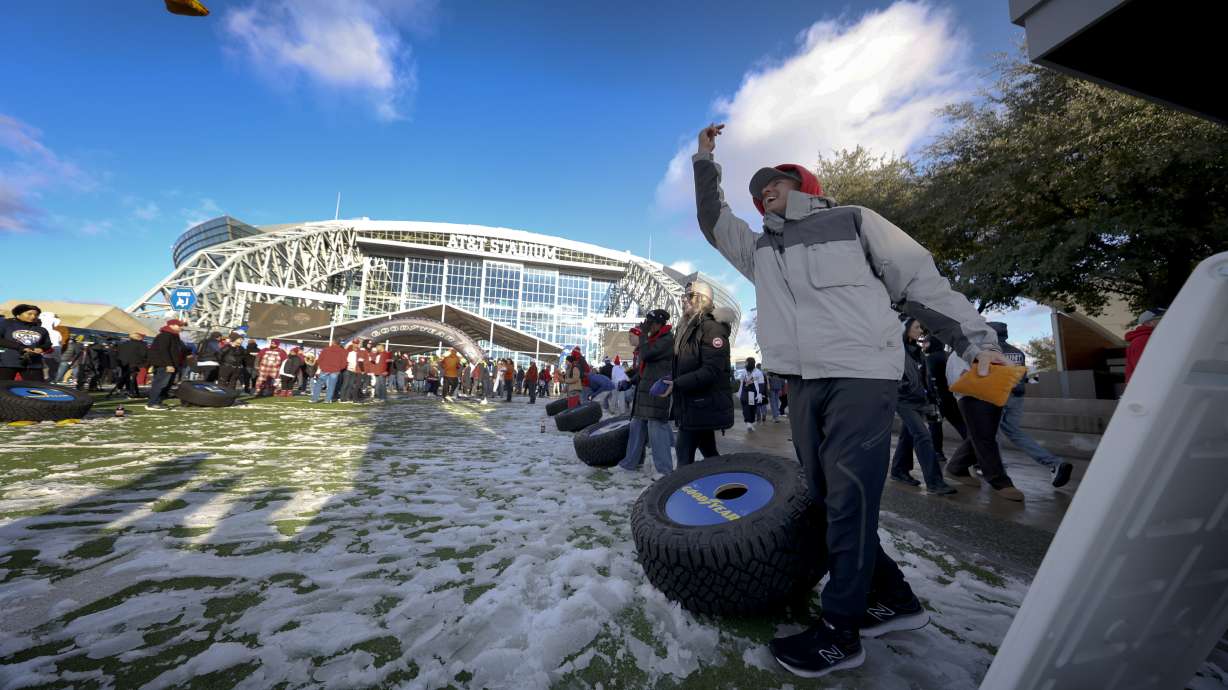 FILE - Tailgaters participate in a game of cornhole outside AT&T Stadium prior to the Cotton Bowl College Football Playoff semifinal game between Ohio State and Texas, Friday, Jan. 10, 2025, in Arlington, Texas.