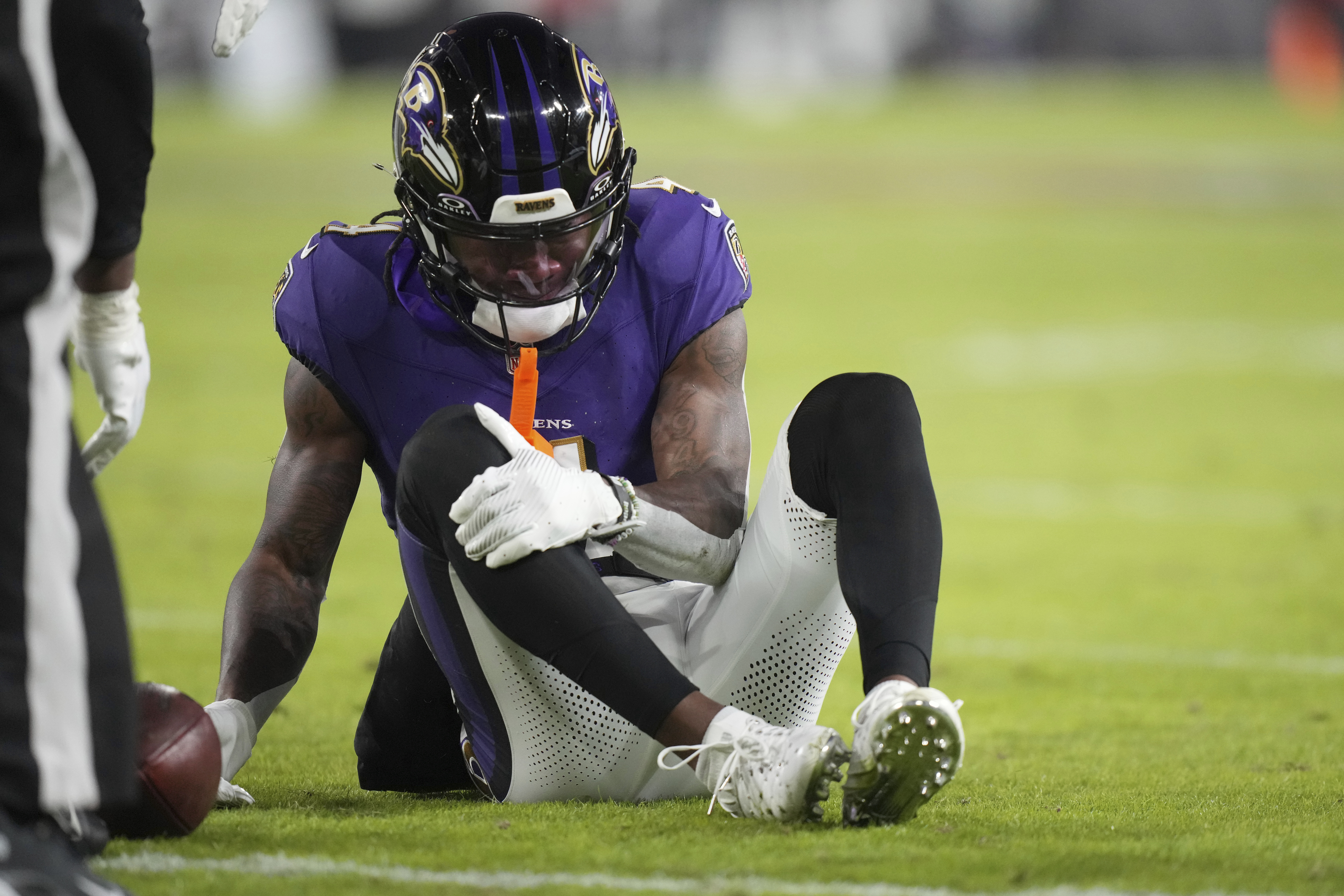 Baltimore Ravens wide receiver Zay Flowers grabs his leg after being injured during the first half of an NFL football game against the Cleveland Browns Saturday, Jan. 4, 2025, in Baltimore.