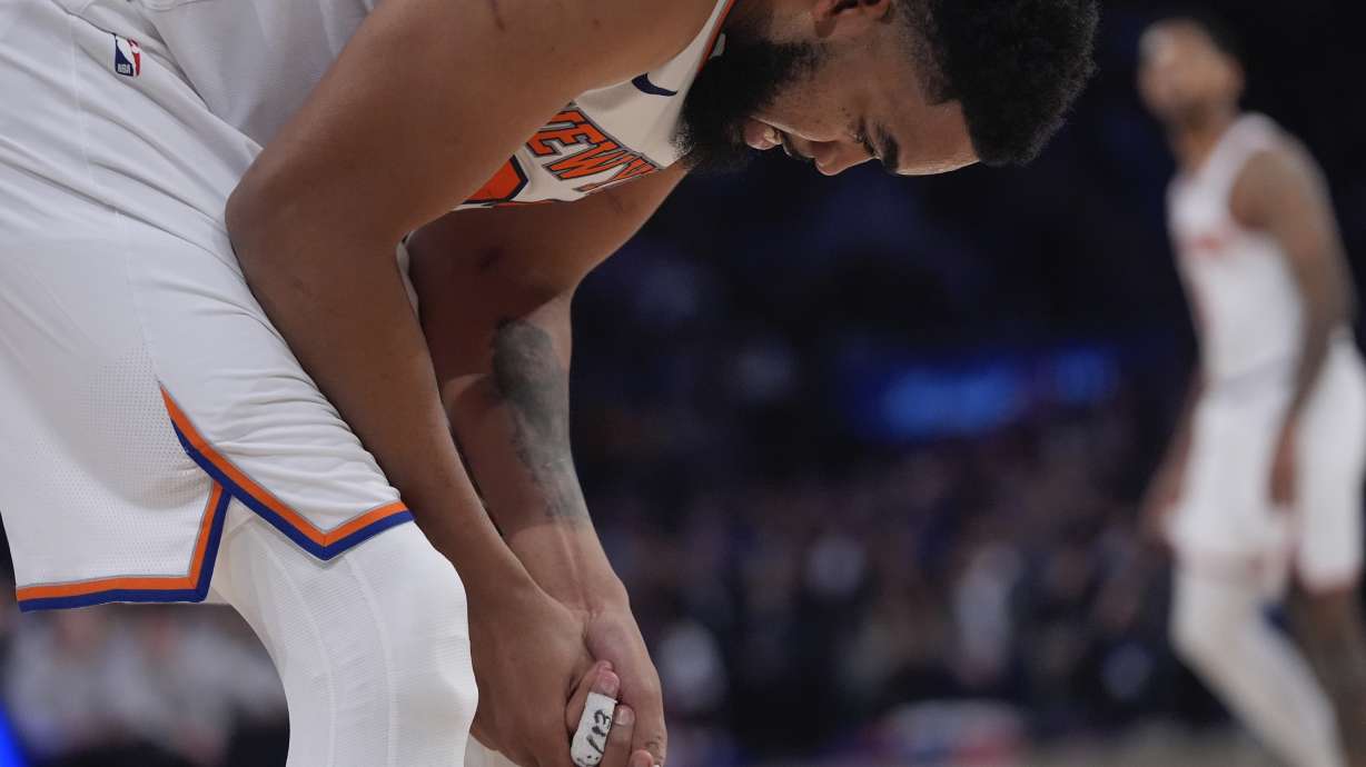 New York Knicks' Karl-Anthony Towns reacts after injuring his hand during the second half of an NBA basketball game against the Detroit Pistons, Monday, Jan. 13, 2025, in New York.