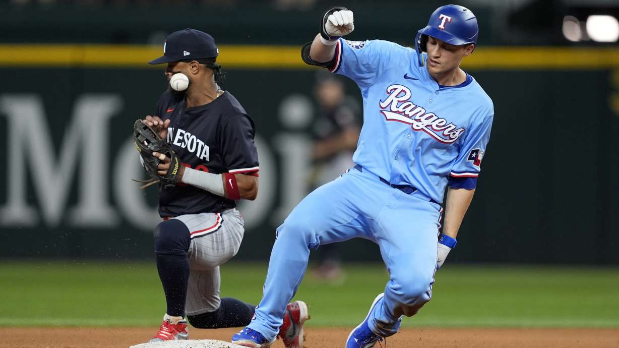 FILE - Minnesota Twins shortstop Willi Castro, left, bobbles the throw to the bag as Texas Rangers' Corey Seager reaches on a run-scoring double in the seventh inning of a baseball game, Aug. 18, 2024, in Arlington, Texas.