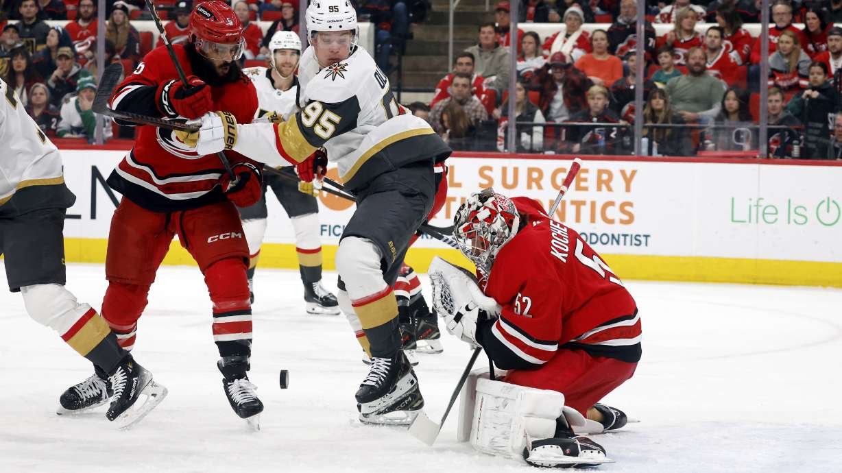 Vegas Golden Knights' Victor Olofsson (95) battles for the puck with Carolina Hurricanes' Jalen Chatfield (5) in from of goaltender Pyotr Kochetkov (52) during the first period of an NHL hockey game in Raleigh, N.C., Friday, Jan. 17, 2025.