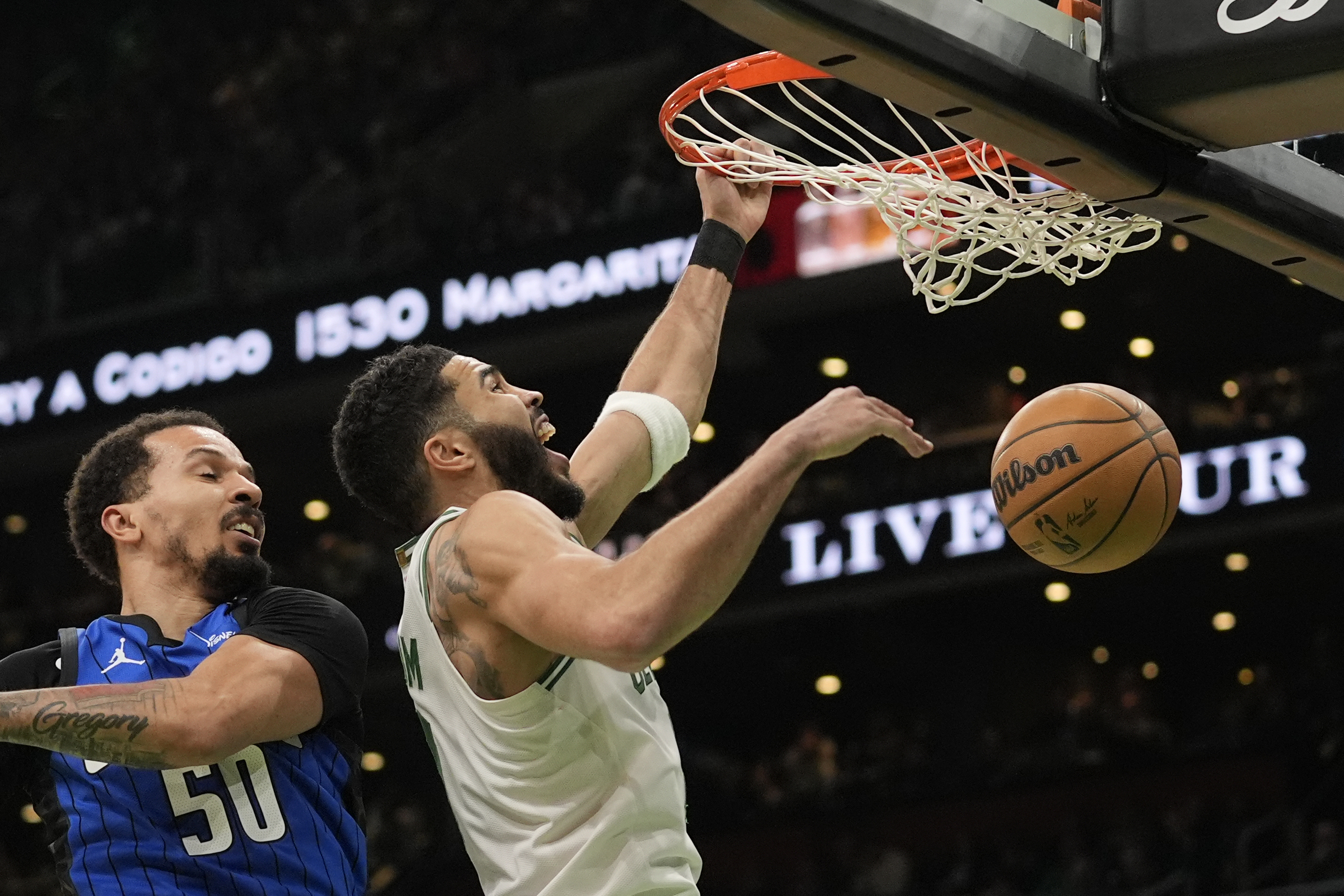 Boston Celtics' Jayson Tatum, right, dunks against Orlando Magic's Cole Anthony (50) during the first half of an NBA basketball game, Friday, Jan. 17, 2025, in Boston.