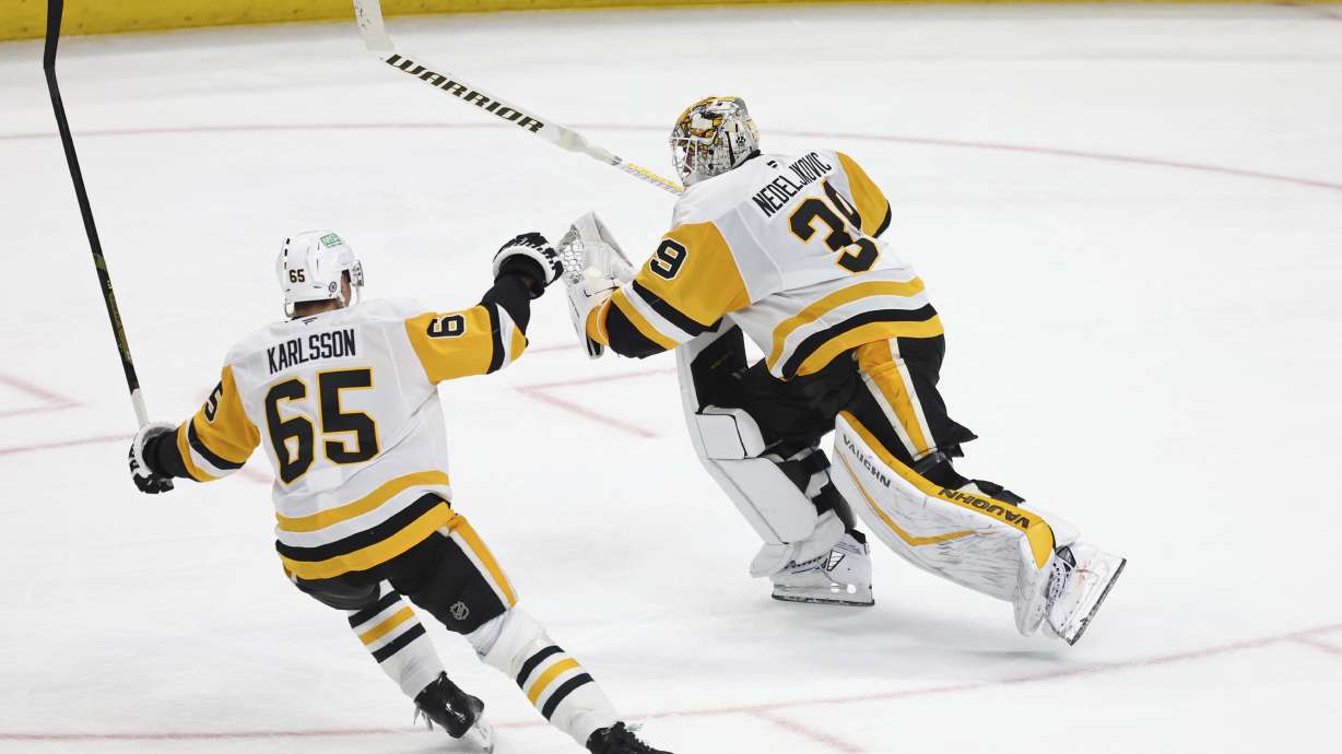 Pittsburgh Penguins goaltender Alex Nedeljkovic (39) celebrates with defenseman Erik Karlsson (65) after scoring during the third period of an NHL hockey game against the Buffalo Sabres, Friday, Jan. 17, 2025, in Buffalo, N.Y.