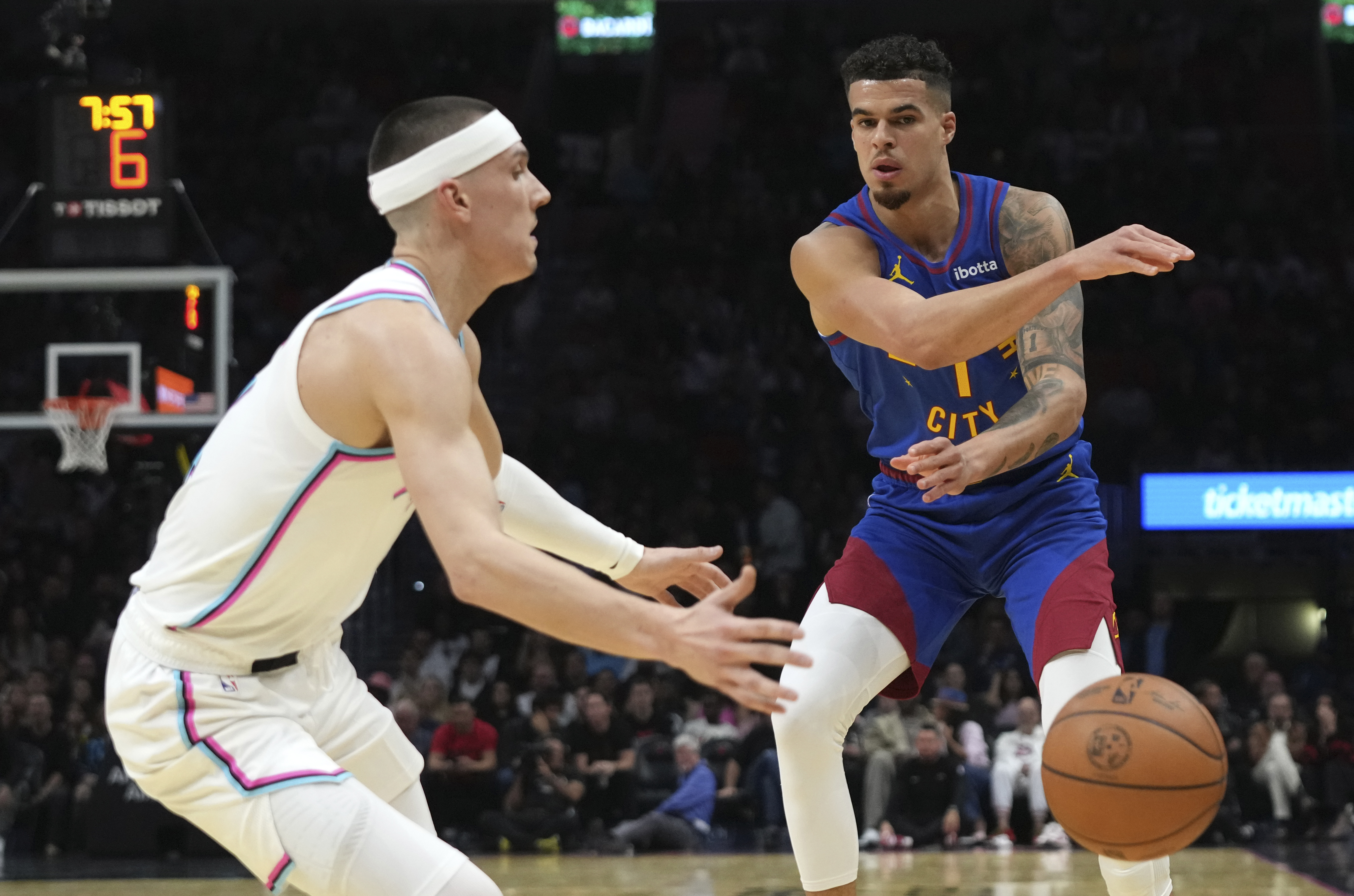 Denver Nuggets forward Michael Porter Jr. (1) passes the ball as Miami Heat guard Tyler Herro, left, defends during the first half of an NBA basketball game, Friday, Jan. 17, 2025, in Miami.