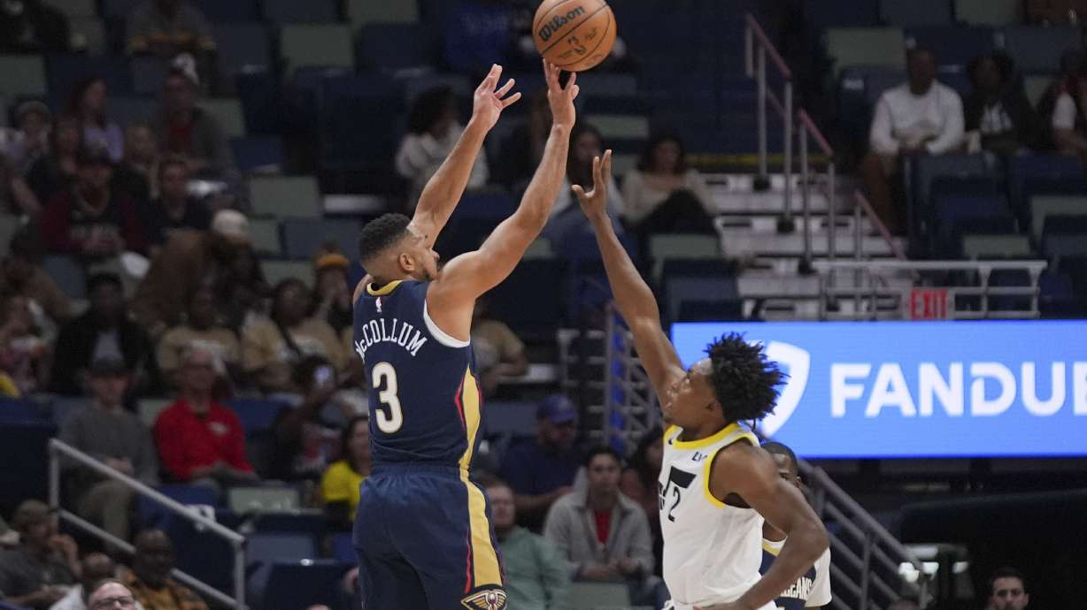 New Orleans Pelicans guard CJ McCollum (3) shoots against Utah Jazz guard Collin Sexton (2) in the first half of an NBA basketball game in New Orleans, Friday, Jan. 17, 2025.