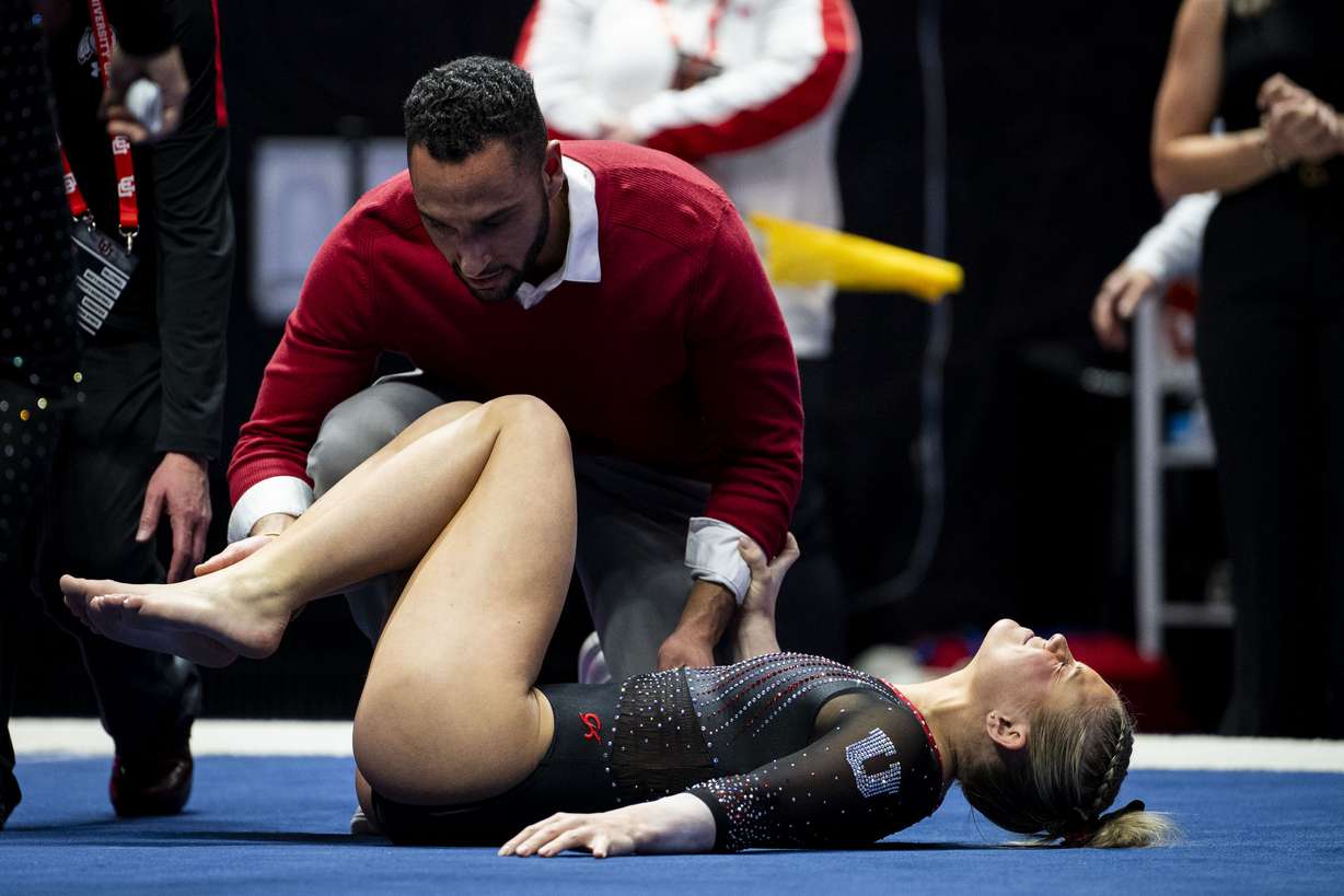 Utah Red Rocks’ Avery Neff is tended to by athletic trainer Zeb Callahan after she sustained an injury competing in the floor routine during a gymnastics meet against Iowa State University held at the Huntsman Center in Salt Lake City on Friday, Jan. 17, 2025.
