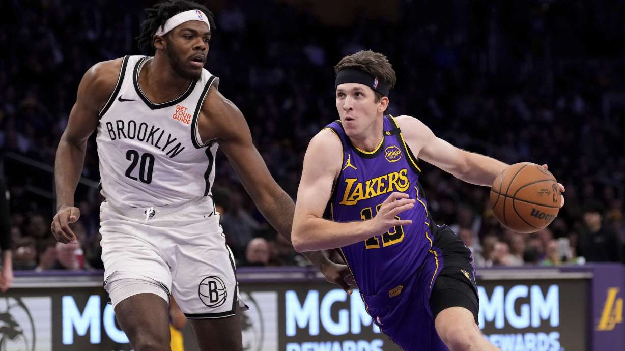 Los Angeles Lakers guard Austin Reaves, right ,drives toward the basket as Brooklyn Nets center Day'Ron Sharpe defends during the first half of an NBA basketball game, Friday, Jan. 17, 2025, in Los Angeles.