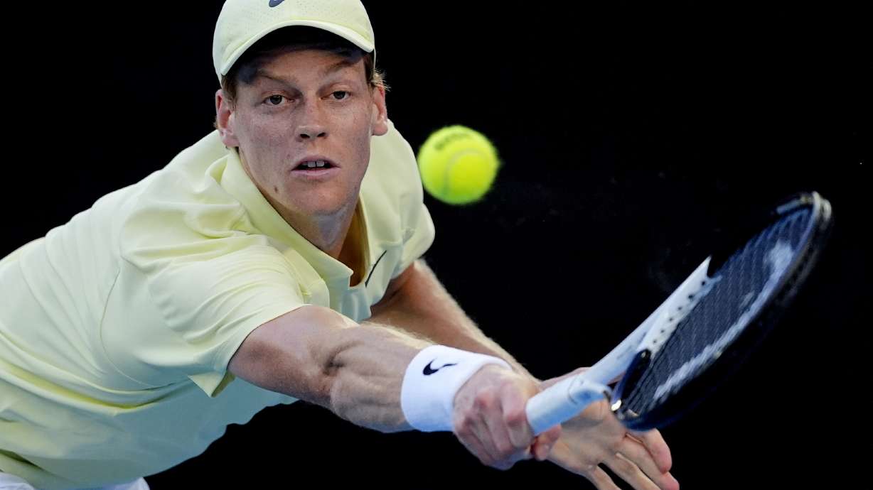 Jannik Sinner of Italy plays a backhand return to Marcos Giron of the U.S. during their third round match at the Australian Open tennis championship in Melbourne, Australia, Saturday, Jan. 18, 2025.