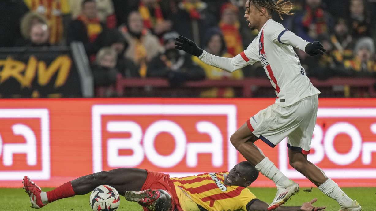 PSG's Bradley Barcola, right, and Lens' Malang Sarr fight for the ball during the French League One soccer match between Lens and Paris Saint-Germain, at the Bollaert-Delelis stadium in Lens, France, Saturday, Jan. 18, 2025.