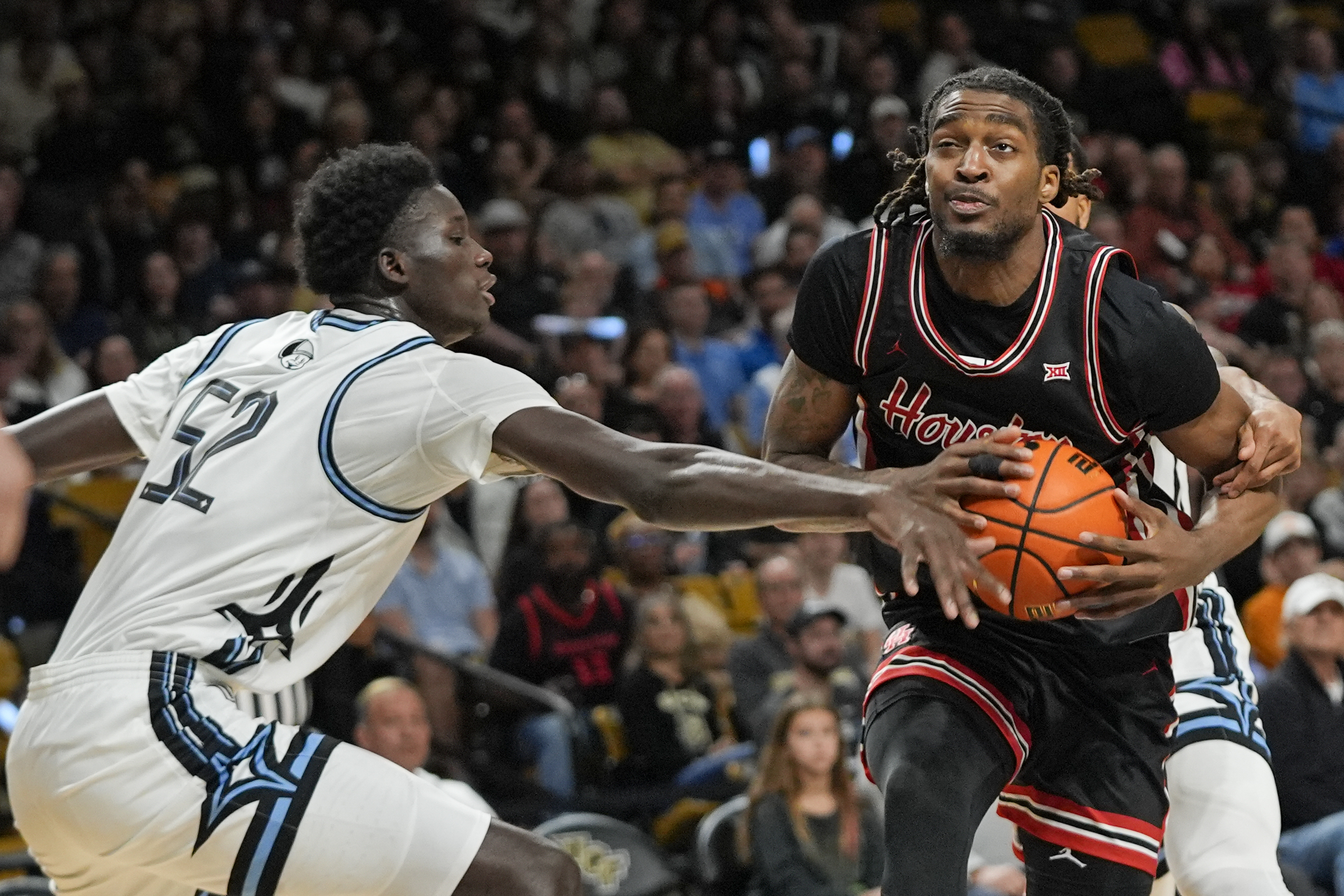 Houston forward Ja'Vier Francis, right, goes to the basket as Central Florida center Moustapha Thiam (52) defends during the first half of an NCAA college basketball game, Saturday, Jan. 18, 2025, in Orlando, Fla. 