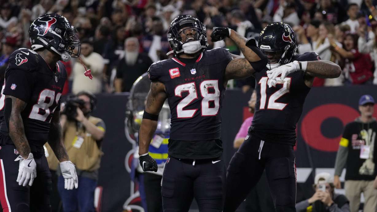 Houston Texans running back Joe Mixon (28) celebrates with Nico Collins (12) and Diontae Johnson (82) after scoring a touchdown during the second half of an NFL wild-card playoff football game Saturday, Jan. 11, 2025, in Houston. The Texans won 32-12.