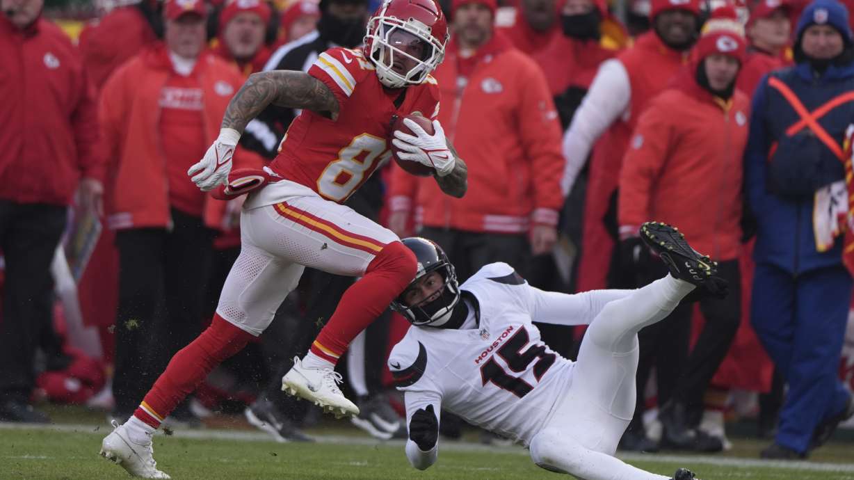 Kansas City Chiefs' Nikko Remigio, left, runs the opening kickoff past Houston Texans' Ka'imi Fairbairn (15) during the first half of an NFL football AFC divisional playoff game Saturday, Jan. 18, 2025, in Kansas City, Mo.