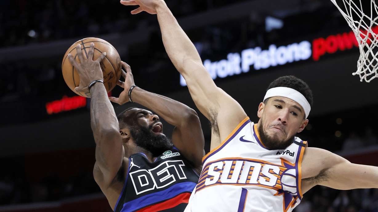 Detroit Pistons forward Tim Hardaway Jr. (8) loses the ball against defense from Phoenix Suns guard Devin Booker (1) during the first half of an NBA basketball game Saturday, Jan. 18, 2025, in Detroit.