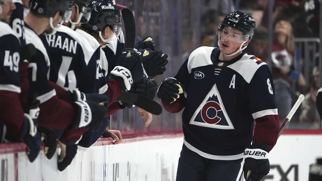 Colorado Avalanche defenseman Cale Makar, right, is congratulated as he passes the team box after scoring against the Dallas Stars in the second period of an NHL hockey game Saturday, Jan. 18, 2025, in Denver.