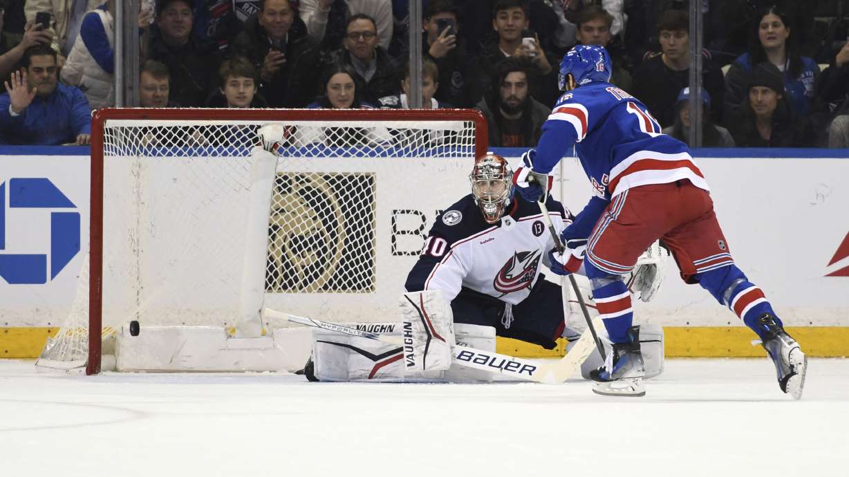 New York Rangers' Vincent Trocheck, right, scores a goal past Columbus Blue Jackets' Daniil Tarasov, left, during a shootout during overtime of an NHL hockey game Saturday, Jan. 18, 2025, in New York.