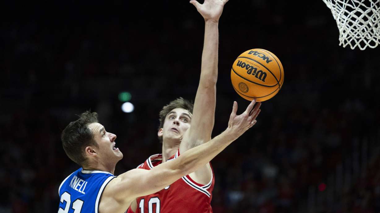 Brigham Young Cougars guard Trevin Knell (21) puts up a shot while being guarded by Utah Utes forward Jake Wahlin (10) during a basketball game between the Utah Utes and the Brigham Young Cougars at the Jon M. Huntsman Center on the campus of the University of Utah in Salt Lake City on Saturday, Jan. 18, 2025.