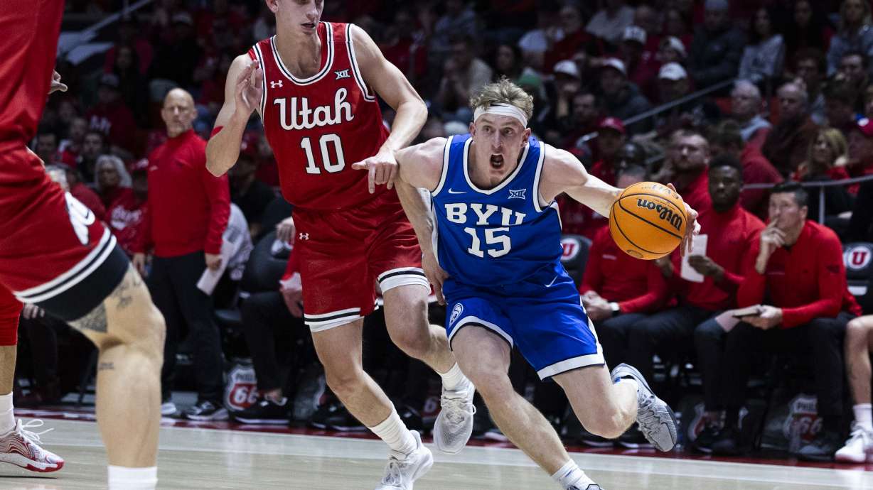 Brigham Young forward Richie Saunders (15) dribbles towards the basket while being guarded by Utah forward Jake Wahlin (10) during a basketball game between the Utah Utes and the Brigham Young Cougars at the Jon M. Huntsman Center on the campus of the University of Utah in Salt Lake City on Saturday, Jan. 18, 2025.
