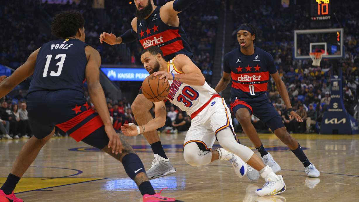 Golden State Warriors' Stephen Curry (30) attempts to drive past Washington Wizards' Jordan Poole (13) in the first quarter of an NBA basketball game in San Francisco, Saturday, Jan. 18, 2025.