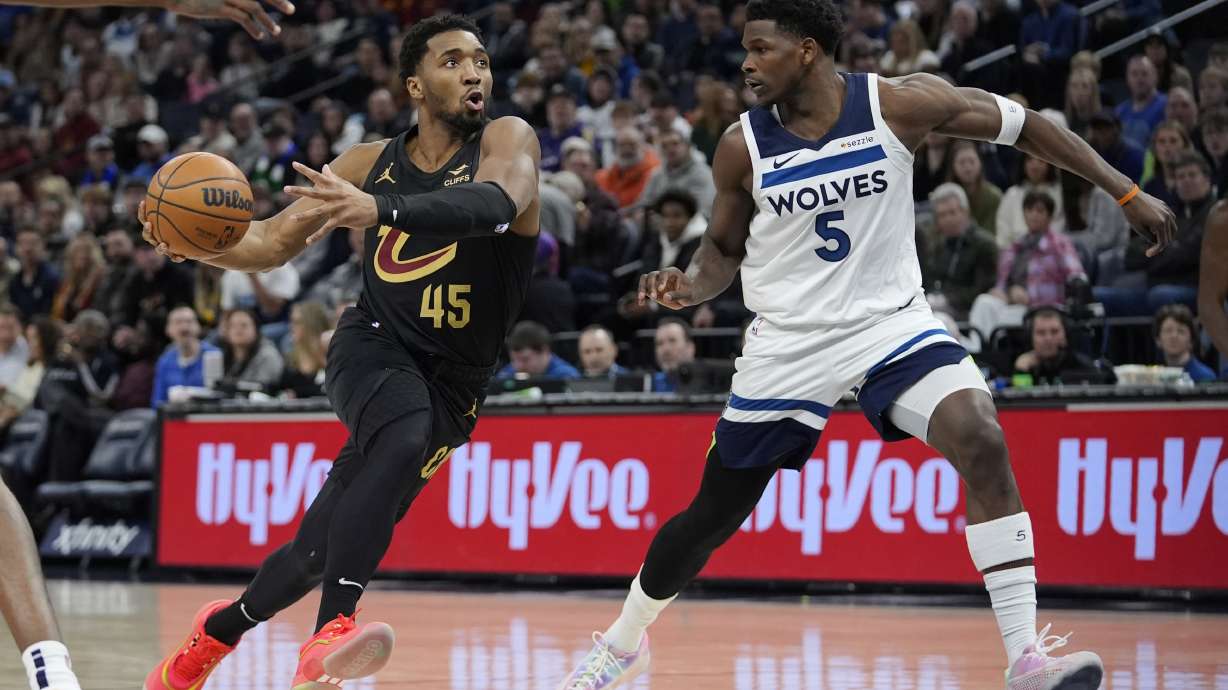 Cleveland Cavaliers guard Donovan Mitchell (45) works toward the basket as Minnesota Timberwolves guard Anthony Edwards (5) defends during the first half of an NBA basketball game, Saturday, Jan. 18, 2025, in Minneapolis.