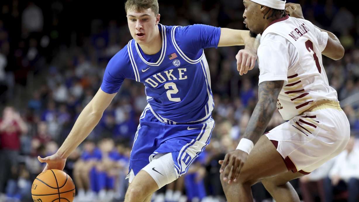 Duke guard Cooper Flagg (2) dribbles around Boston College guard Roger McFarlane (3) during the first half of an NCAA college basketball game Saturday, Jan. 18, 2025, in Boston.