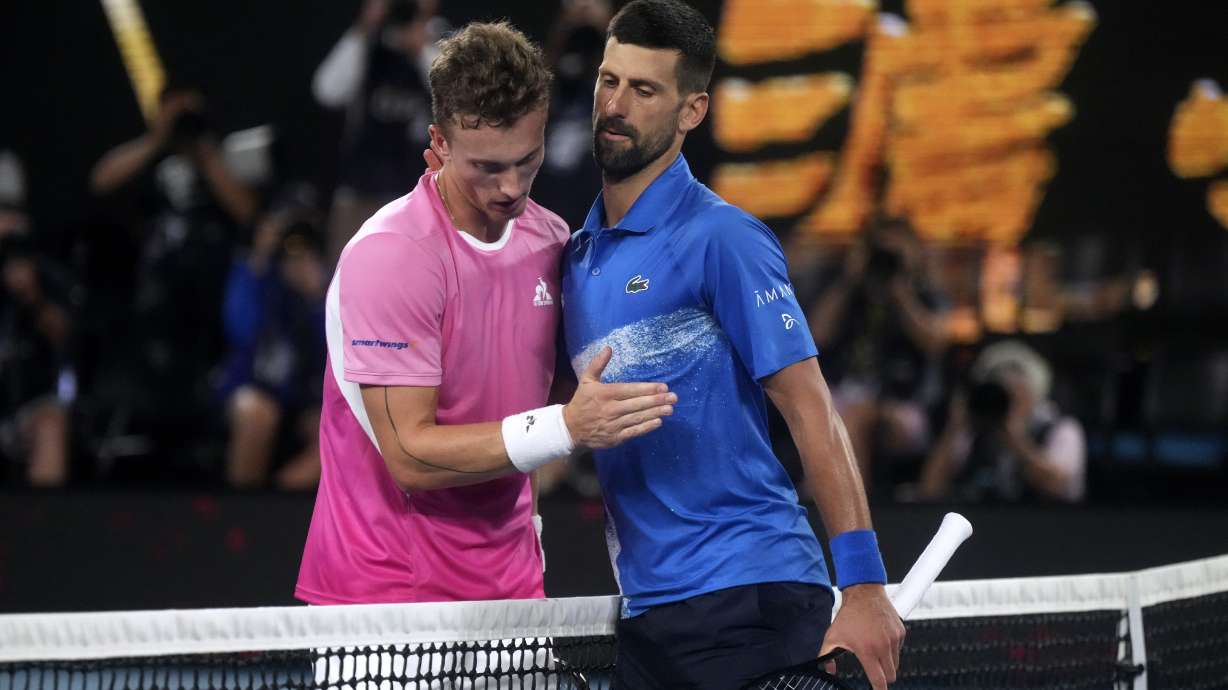 Novak Djokovic, right, of Serbia is congratulated by Jiri Lehecka of the Czech Republic, left, after their fourth round match at the Australian Open tennis championship in Melbourne, Australia, Sunday, Jan. 19, 2025.