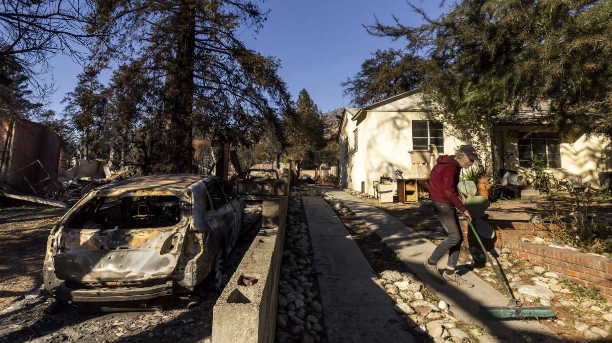David Slater, right, clears the driveway from his home, spared from the Eaton Fire, Jan. 12, in Altadena, Calif.