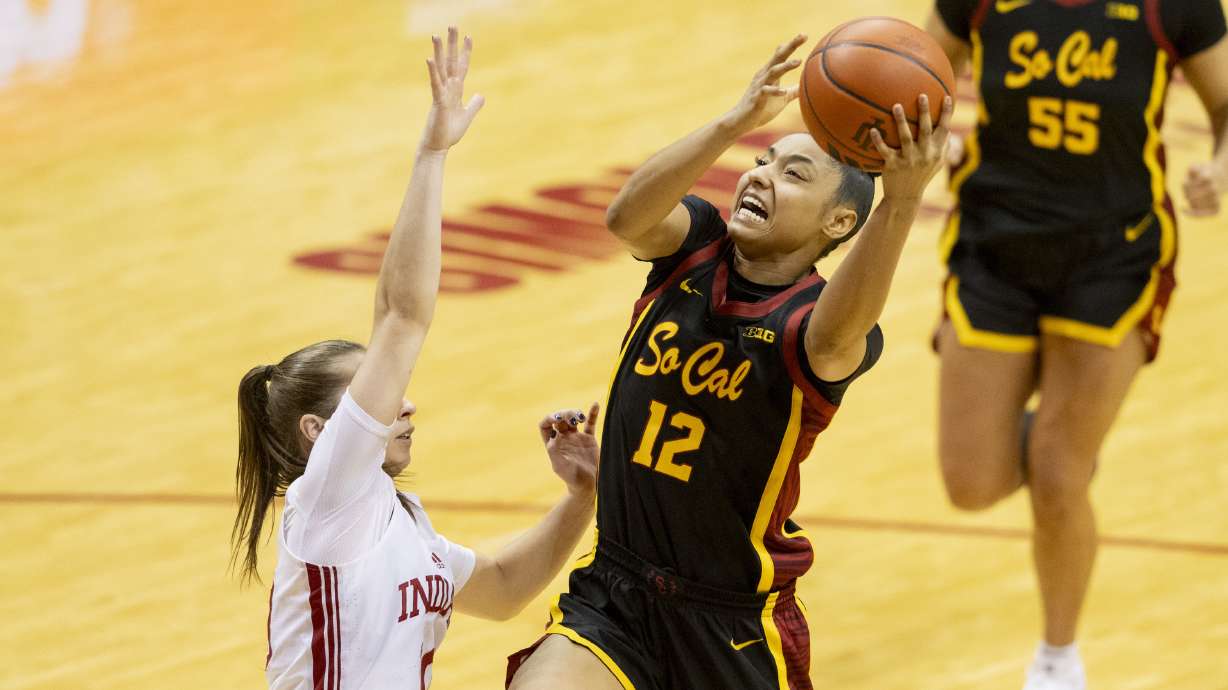 USC guard JuJu Watkins (12) shoots while being defended by Indiana guard Lexus Bargesser, left, during the second half of an NCAA college basketball game, Sunday, Jan. 19, 2025, in Bloomington, Ind.