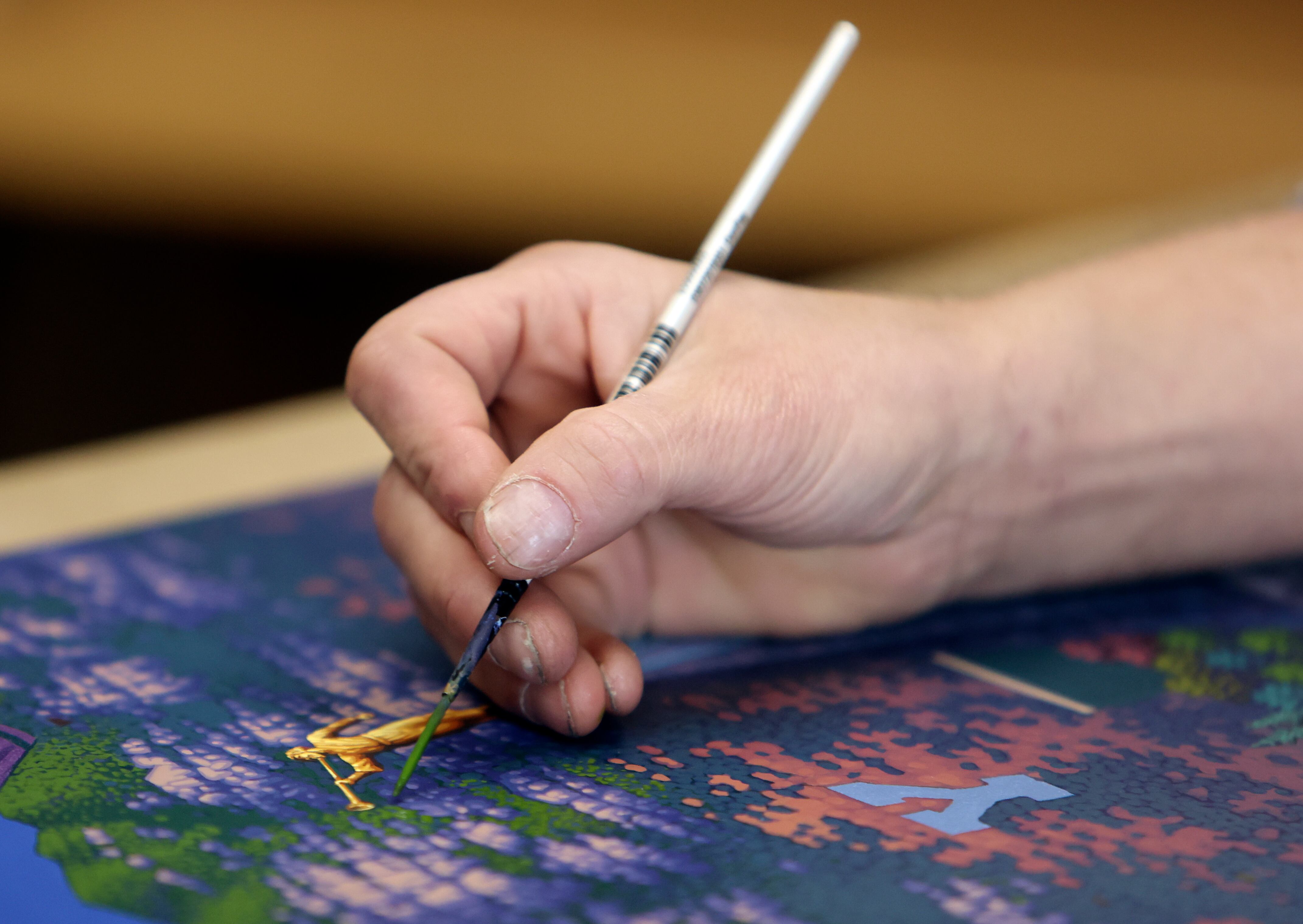 Artist Eric Dowdle paints trees on mountains above Provo at Dowdle Puzzles in Lindon on Wednesday, Jan. 8.