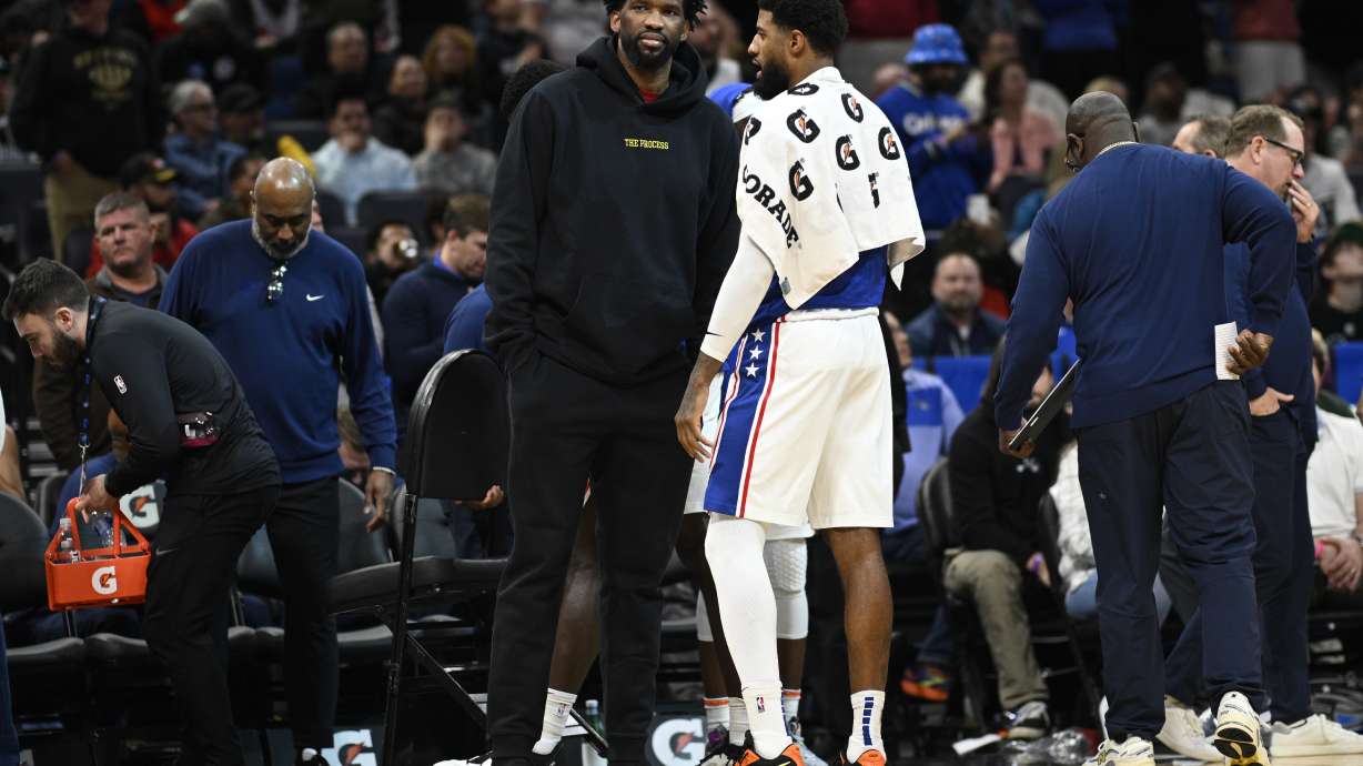 FILE - Philadelphia 76ers center Joel Embiid, center left, talks with forward Paul George during a timeout in the second half of an NBA basketball game against the Orlando Magic, Sunday, Jan. 12, 2025, in Orlando, Fla.