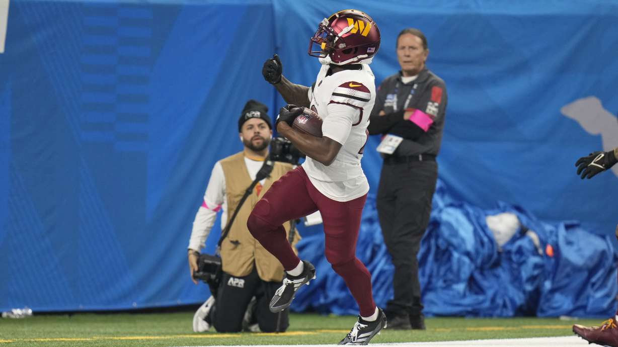 Washington Commanders safety Quan Martin (20) returns a 40-yard interception for a touchdown against the Detroit Lions during the first half of an NFL football divisional playoff game, Saturday, Jan. 18, 2025, in Detroit.