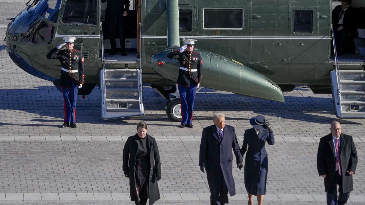First Lady Melania Trump and President Donald Trump walk as former President Joe Biden salutes after boarding a Marine helicopter en route to Joint Base Andrews after the 60th Presidential Inauguration, Monday at the U.S. Capitol in Washington.