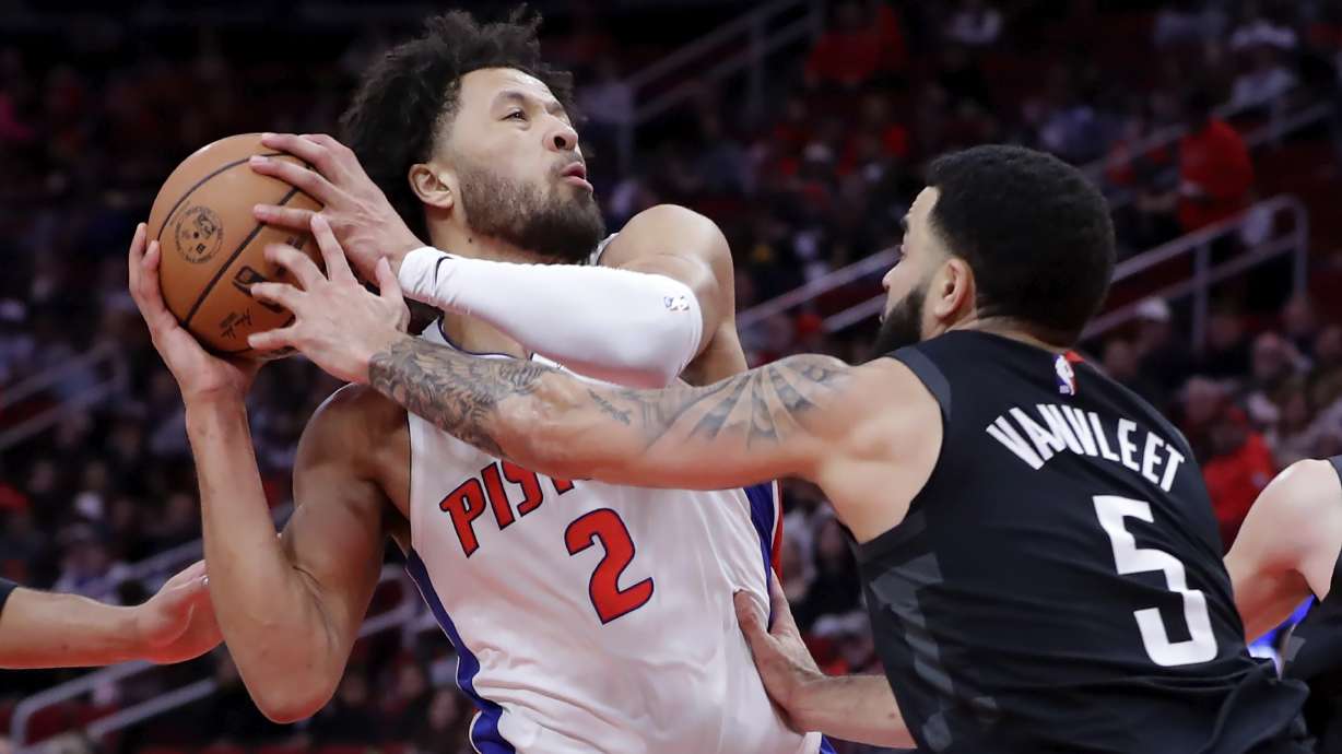 Detroit Pistons guard Cade Cunningham (2) protects the ball on a drive to the basket as Houston Rockets guard Fred VanVleet (5) reaches in during the first half of an NBA basketball game Monday, Jan. 20, 2025, in Houston.