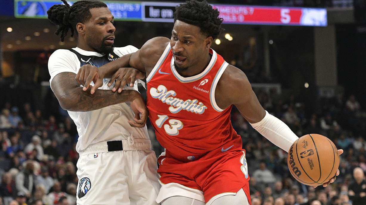 Memphis Grizzlies forward Jaren Jackson Jr. (13) handles the ball against Minnesota Timberwolves center Naz Reid in the first half of an NBA basketball game Monday, Jan. 20, 2025, in Memphis, Tenn.
