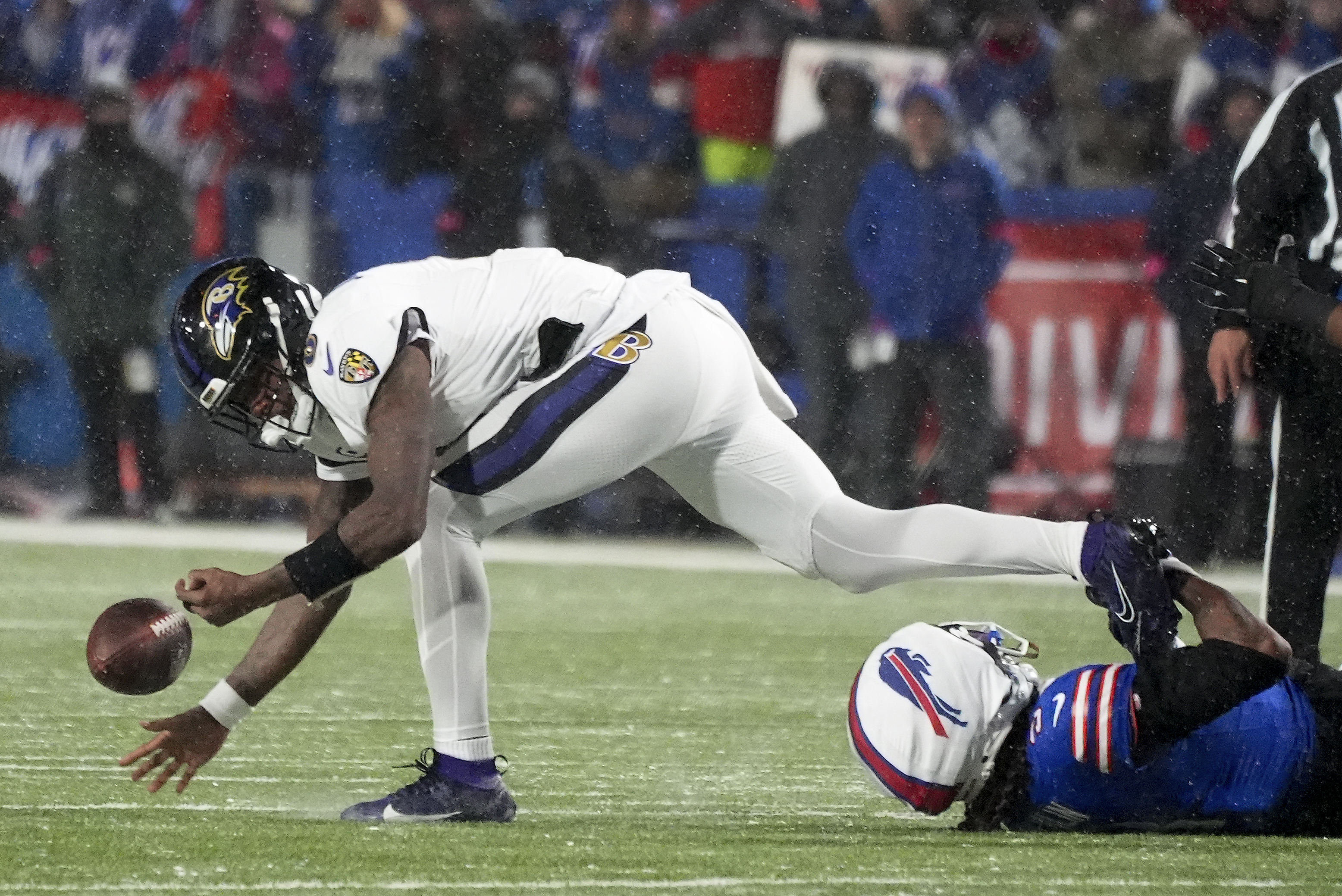 Baltimore Ravens quarterback Lamar Jackson (8) fumbles the football as he is tackled by Buffalo Bills safety Damar Hamlin (3) during the second quarter of an NFL divisional playoff football game, Sunday, Jan. 19, 2025, in Orchard Park, N.Y.