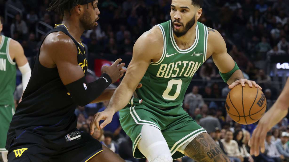 Boston Celtics forward Jayson Tatum (0) drives to the basket against Golden State Warriors guard Buddy Hield, left, during the first half of an NBA basketball game in San Francisco, Monday, Jan. 20, 2025.