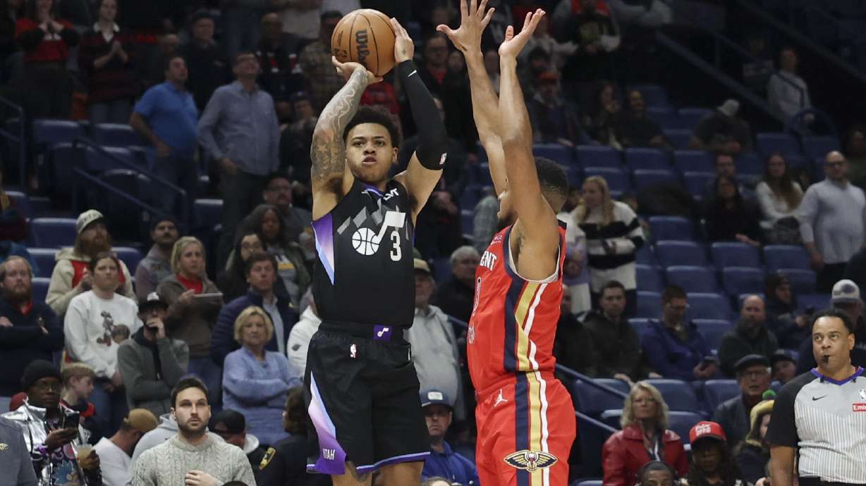 Utah Jazz guard Keyonte George, left, shoots a 3-pointer over New Orleans Pelicans guard CJ McCollum in the first half of an NBA basketball game in New Orleans, Monday, Jan. 20, 2025.
