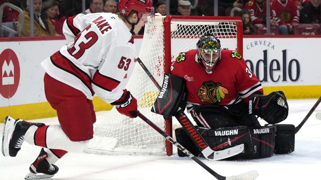Chicago Blackhawks goaltender Petr Mrazek, right, watches the puck while Carolina Hurricanes right wing Jackson Blake controls it during the second period of an NHL hockey game in Chicago, Monday, Jan. 20, 2025.