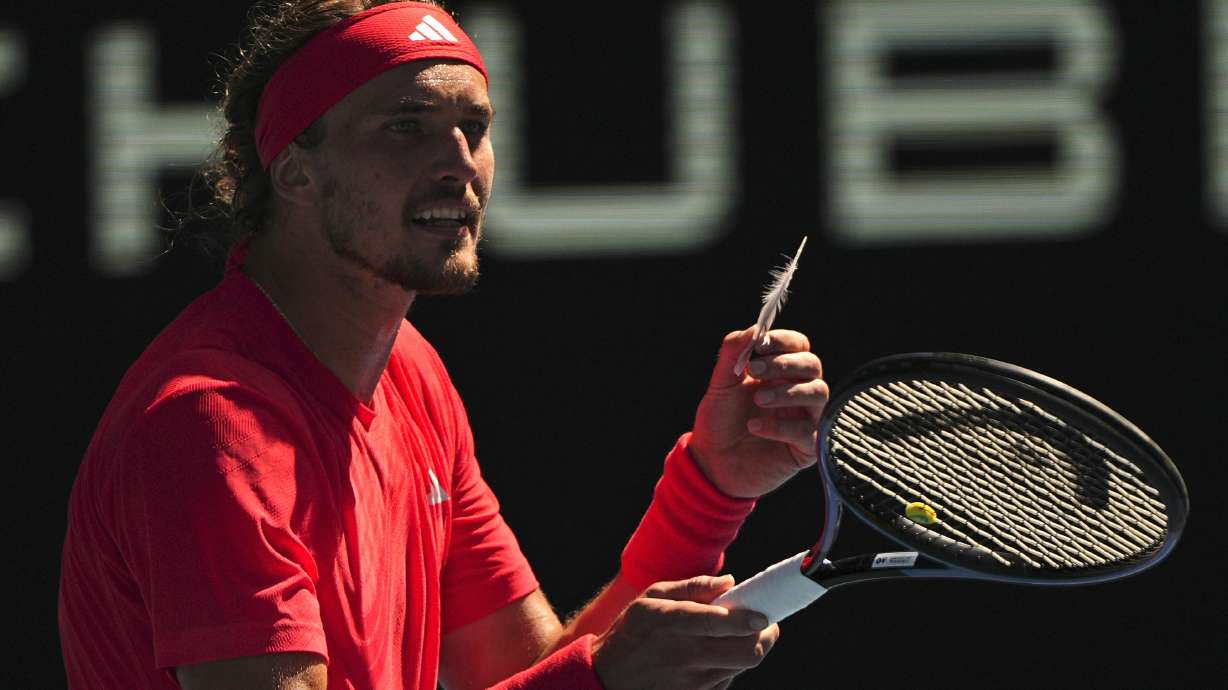 Alexander Zverev of Germany reacts as he holds a feather during his quarterfinal match against Tommy Paul of the U.S. during their quarterfinal match at the Australian Open tennis championship in Melbourne, Australia, Tuesday, Jan. 21, 2025.