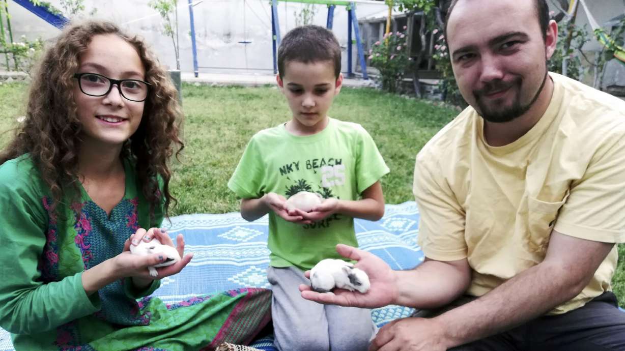 This family photo shows Ryan Corbett holding rabbits with his daughter Miriam and son Caleb in Kabul, Afghanistan, in 2020. Corbett, who was detained by the Taliban in August 2022, was released Monday in a prisoner swap.